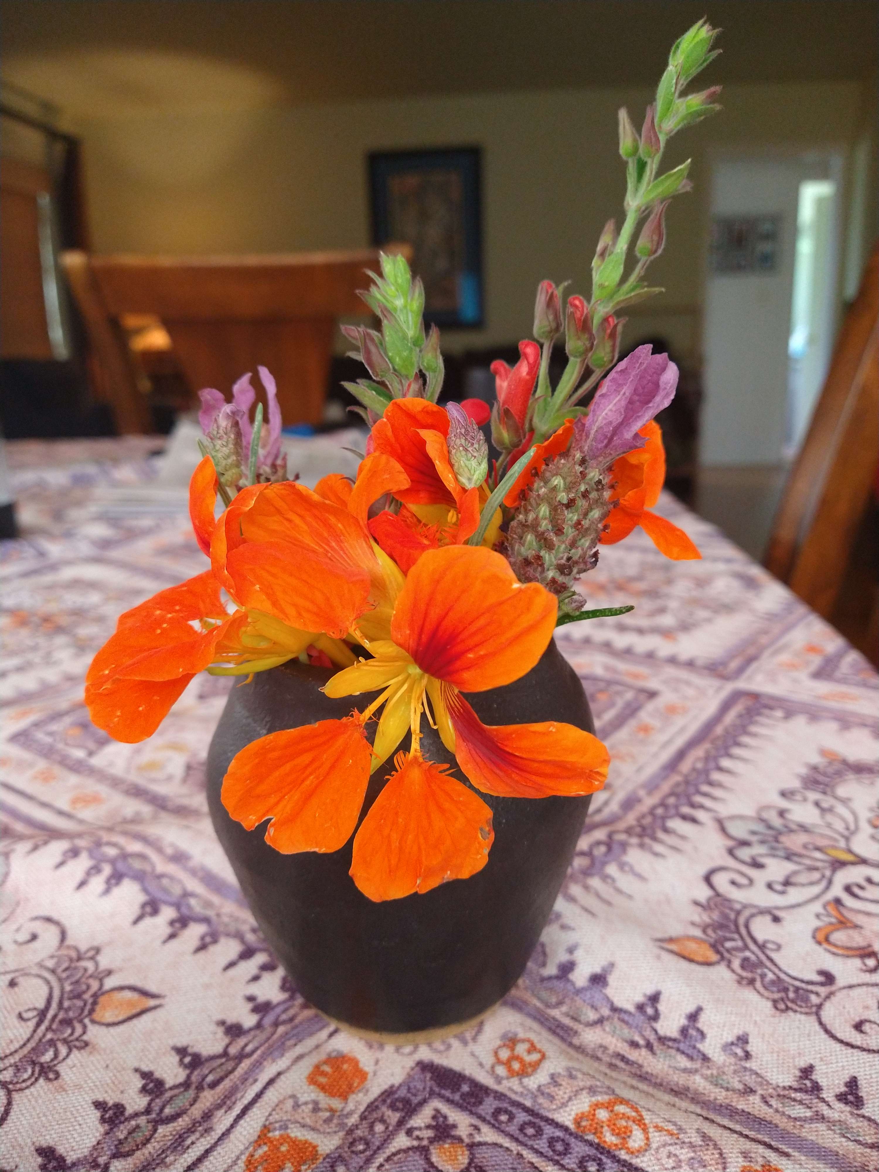the same vase with orange nasturtiums and other flowers.